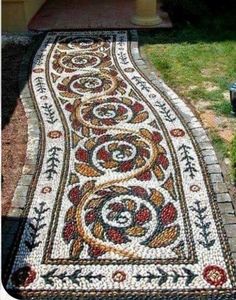 a walkway made out of mosaic tiles in front of a house