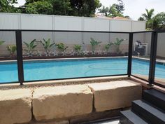 an empty swimming pool with steps leading up to it and a fenced in area next to it