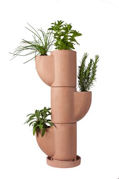 three planters are stacked on top of each other with plants growing out of them