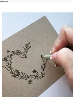 someone is drawing a wreath on a piece of paper