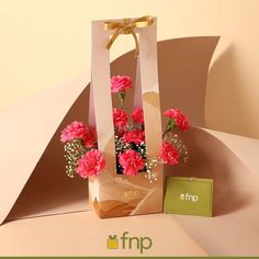 pink carnations and baby's breath in a paper bag