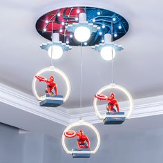 three circular lights hanging from the ceiling with spiderman figurines