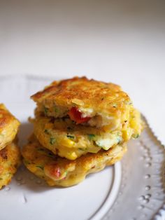 two crab cakes stacked on top of each other on a white plate next to a fork