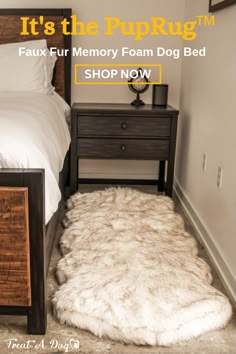 a bed with a furry rug on the floor next to a night stand and nightstand