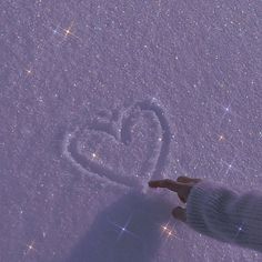 a person standing in the snow with their hand out to someone writing love on it