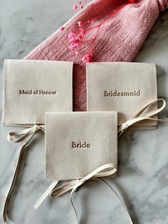 three tags with the names of bride, maid of honor and bridesmaid on them