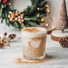 there is a drink that has been made with ice and cinnamon on the table next to christmas decorations