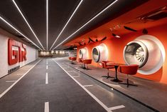 an empty parking garage with red chairs and round mirrors