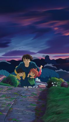 two people and a child are standing on a path in front of mountains at night