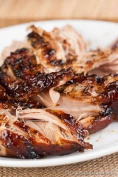 barbecued pork with bbq sauce on a white plate, ready to be eaten