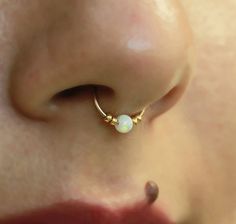 a close up view of a person's nose with an ope piercing on it