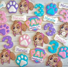 decorated cookies with dogs and numbers are displayed on a white table top, along with the names of their favorite children's books