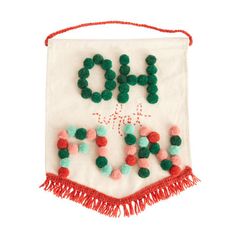 an embroidered banner with pom poms hanging from it's sides and the words joy on it