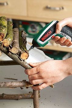 a person using a power tool to cut up tree branches with a circular sawtooth