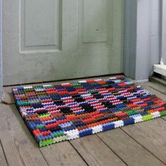 a multicolored rug on the floor in front of a door