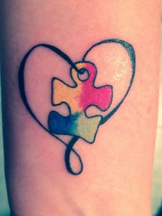 a heart shaped puzzle piece tattoo on the leg