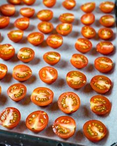 tomatoes on a baking sheet ready to go in the oven for roasting and cooking