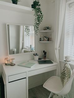 a white desk with a mirror, chair and potted plant on top of it