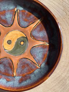 a ceramic plate with a yin - yang symbol on it's center and two black dots in the middle