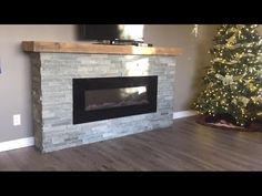 a living room with a christmas tree and a flat screen tv mounted on the wall