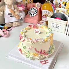 a birthday cake sitting on top of a table next to other decorations and items that include an old telephone