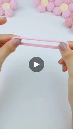 two hands holding up a pink paper with flowers on it and the video is being viewed from above