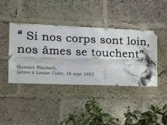 a sign posted on the side of a brick wall that says, si nos cops sont loin, nos ames se touchent