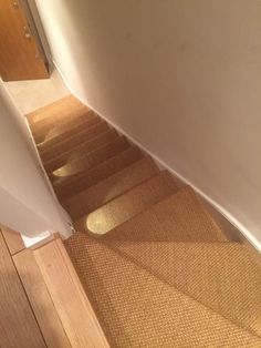 a cat is sitting on the floor next to some stairs