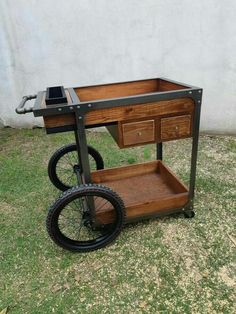 a wooden cart with wheels and drawers on the grass