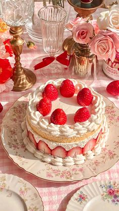 there is a cake with strawberries on the plate and pink flowers in the background