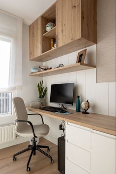 a desk with a computer on top of it in front of a window and some bookshelves