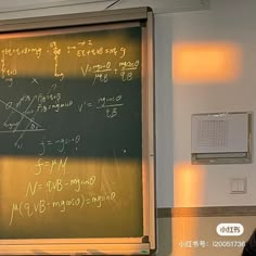 a man standing in front of a blackboard with writing on it