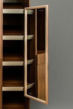 an open wooden cabinet with shelves and drawers