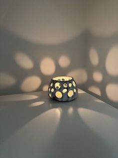 a vase sitting on top of a table in the middle of a room with light coming through it