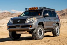 the front end of a gray four - doored suv with lights on it's roof