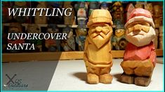 two wooden santa figurines sitting next to each other