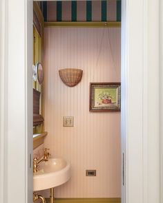 an open door leading to a bathroom with a sink and mirror on the wall above it