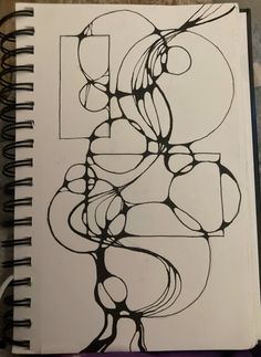 a drawing is shown on top of a spiral notebook with black and white lines in the middle