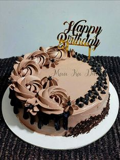 a birthday cake with chocolate frosting and flowers on top that reads, happy birthday