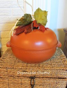 an orange pot sitting on top of a wicker box