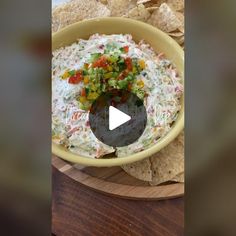 a bowl filled with chips and salsa on top of a wooden table