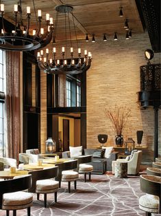 an elegant lobby with chandeliers and chairs in front of a large glass window