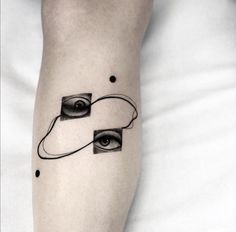 a person's leg with an eye tattoo on the left side of their arm