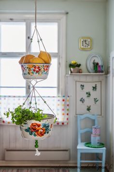 three hanging baskets filled with fruit and vegetables in a child's playroom area