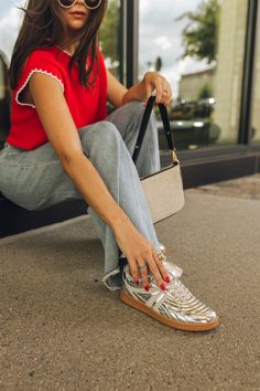 Side view of female model wearing the Madrid Silver Sneakers with jeans and a red top. Silver Tennis Shoes Outfit, Silver Shoes Outfit Casual, Low Top Sneakers Outfit, Metallic Sneakers Outfit, Gold Sneakers Outfit, Silver Sneakers Outfit, Silver Shoes Outfit, Steve Madden Sneakers Outfit, Madrid Outfits