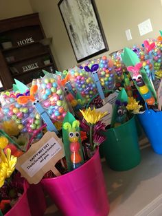 there are many colorful buckets with candy in them