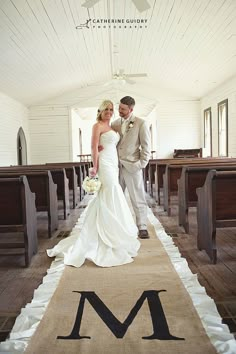 a bride and groom standing in front of the alter at their wedding ceremony with monogrammed aisle runner