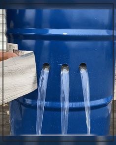 a large blue barrel with water coming out of it