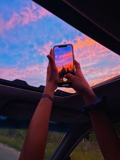 a person taking a photo with their cell phone in the back seat of a car