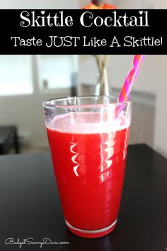 a glass filled with red liquid sitting on top of a table